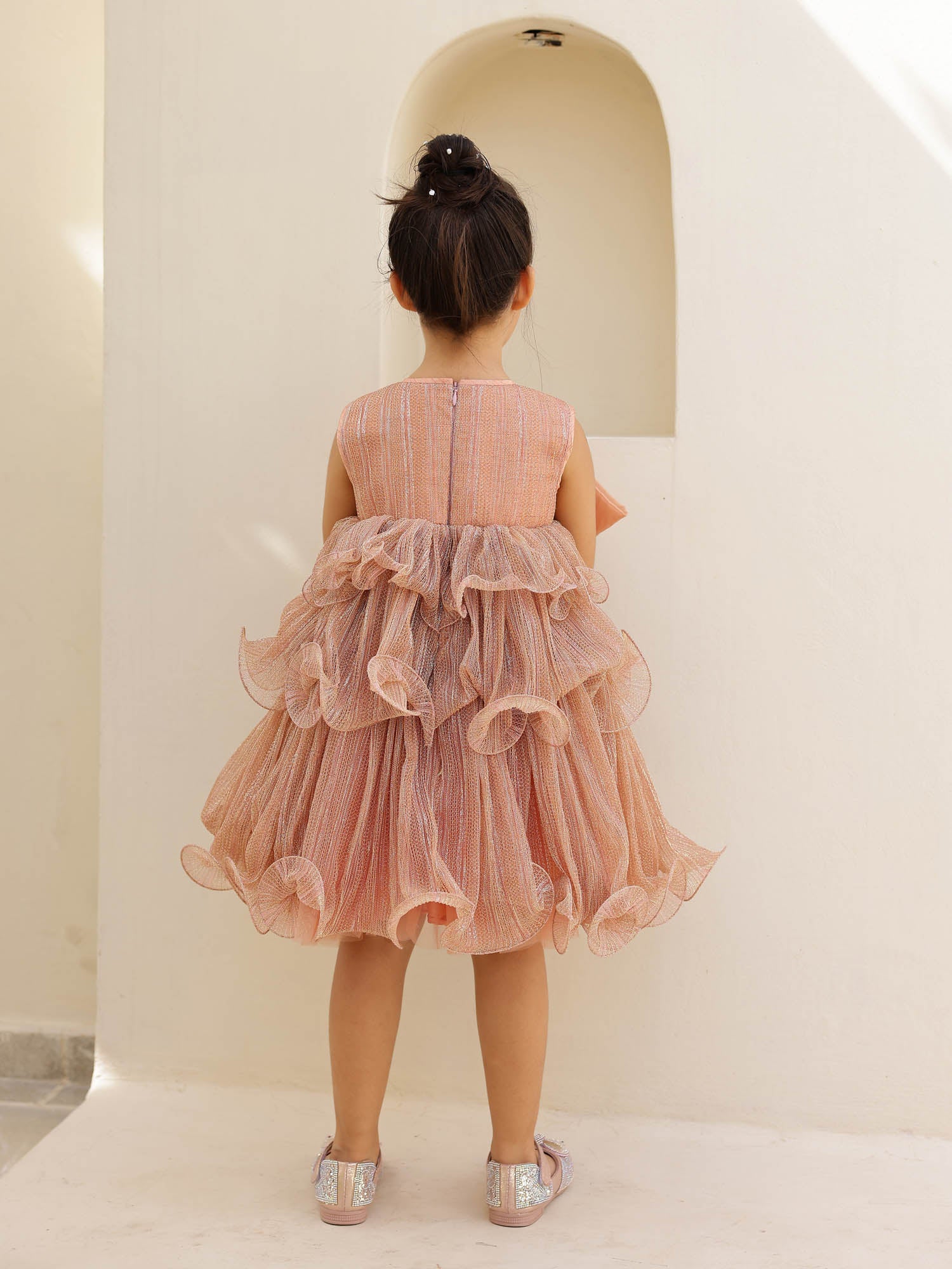 Sleeveless, tiered, glitter dress with a prominent satin bow.