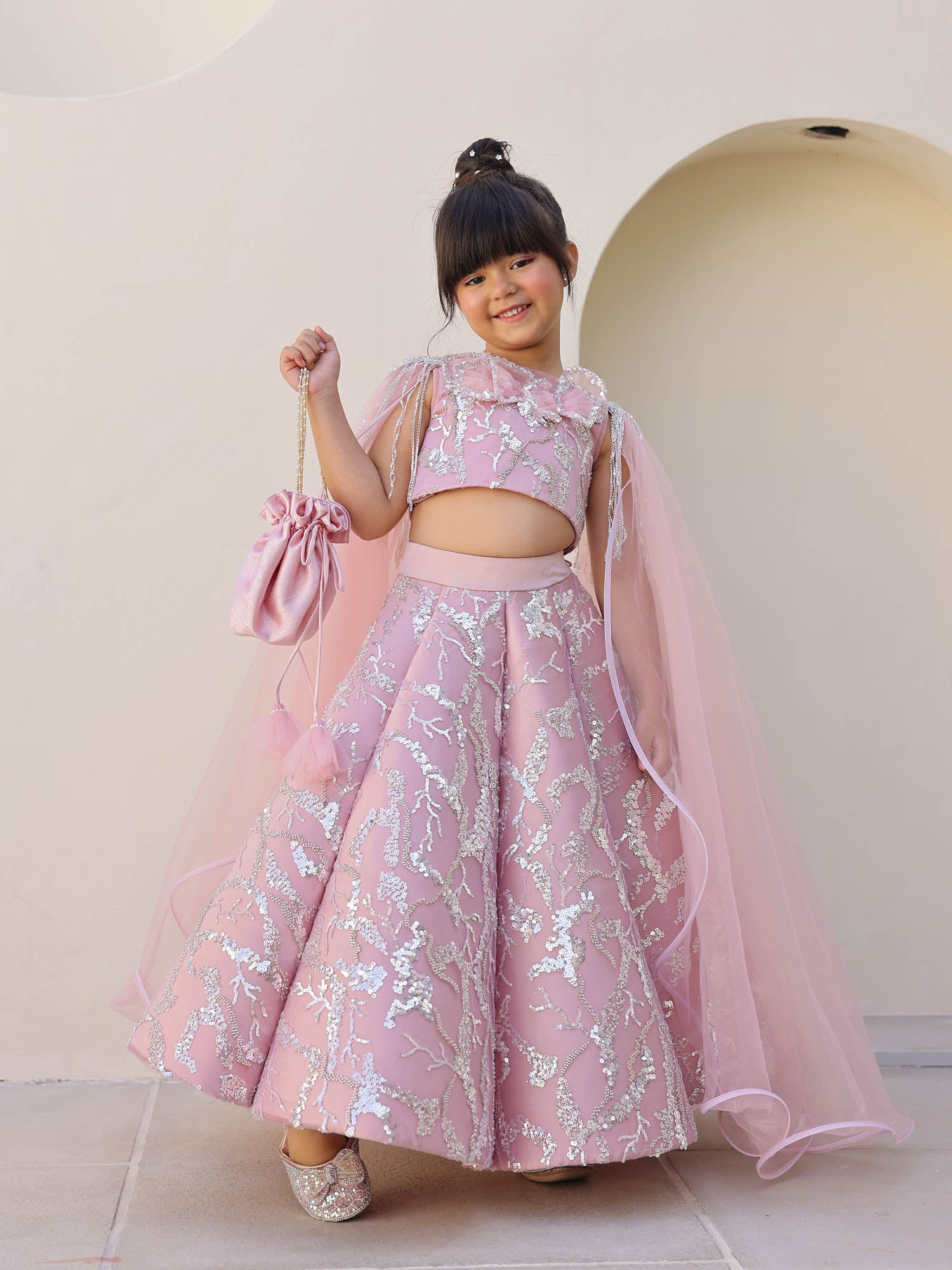 Girl wearing blush pink sequin lehenga set.