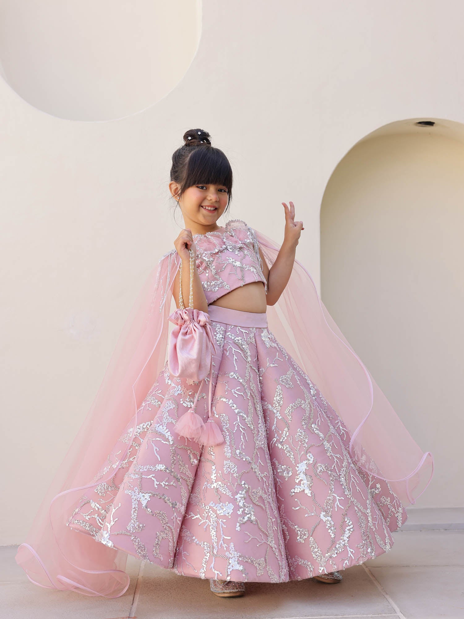 Cowl-flared lehenga with shoulder cape dupatta.