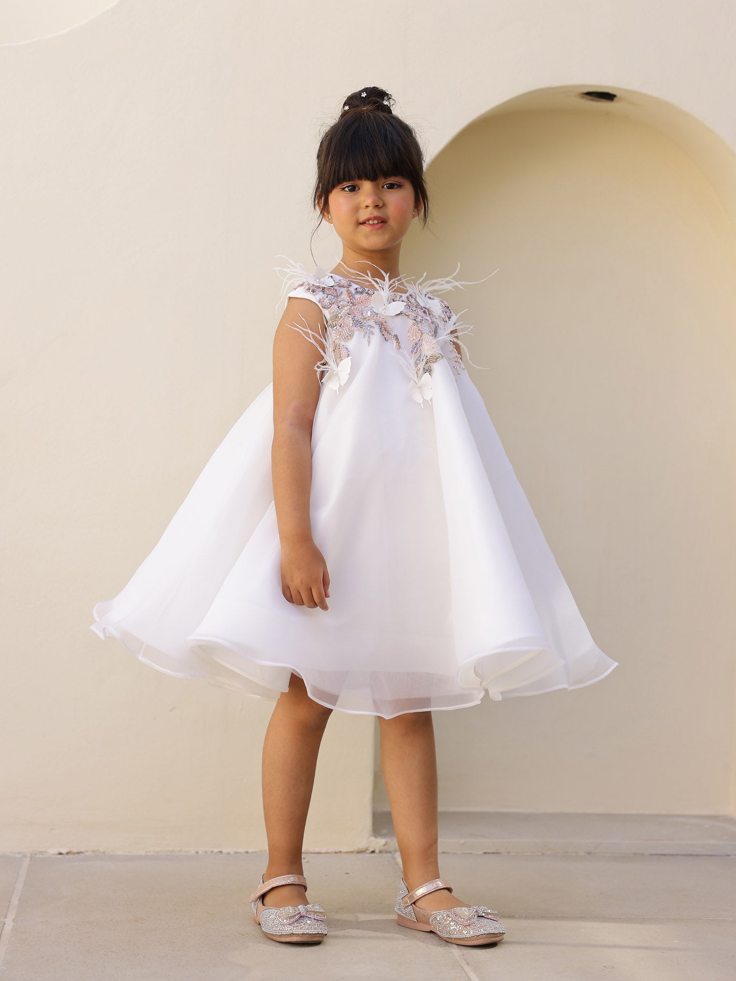 Detailed embroidery and feather embellishments on bodice