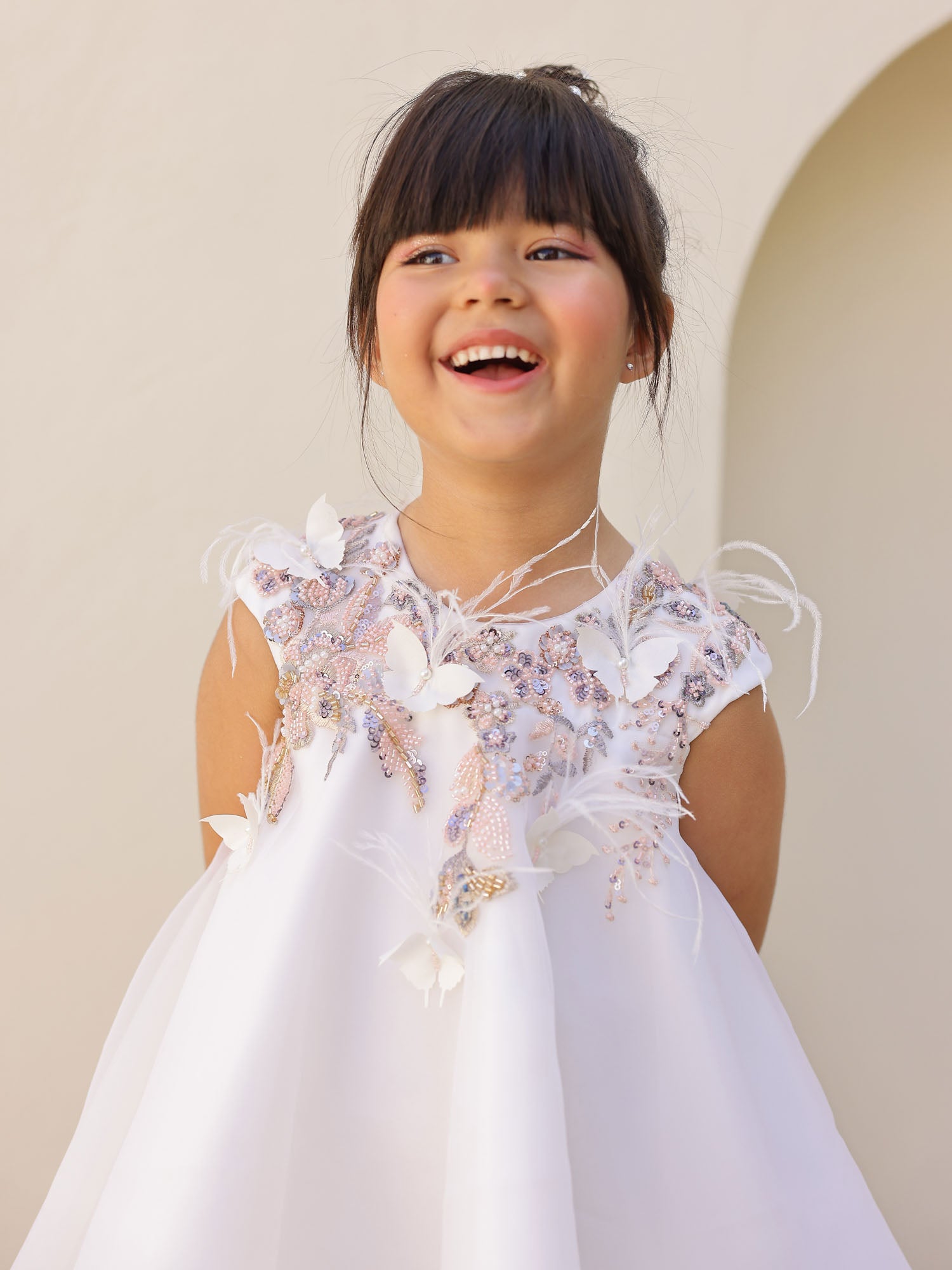 Close-up of embroidered neckline with feathers and butterflies