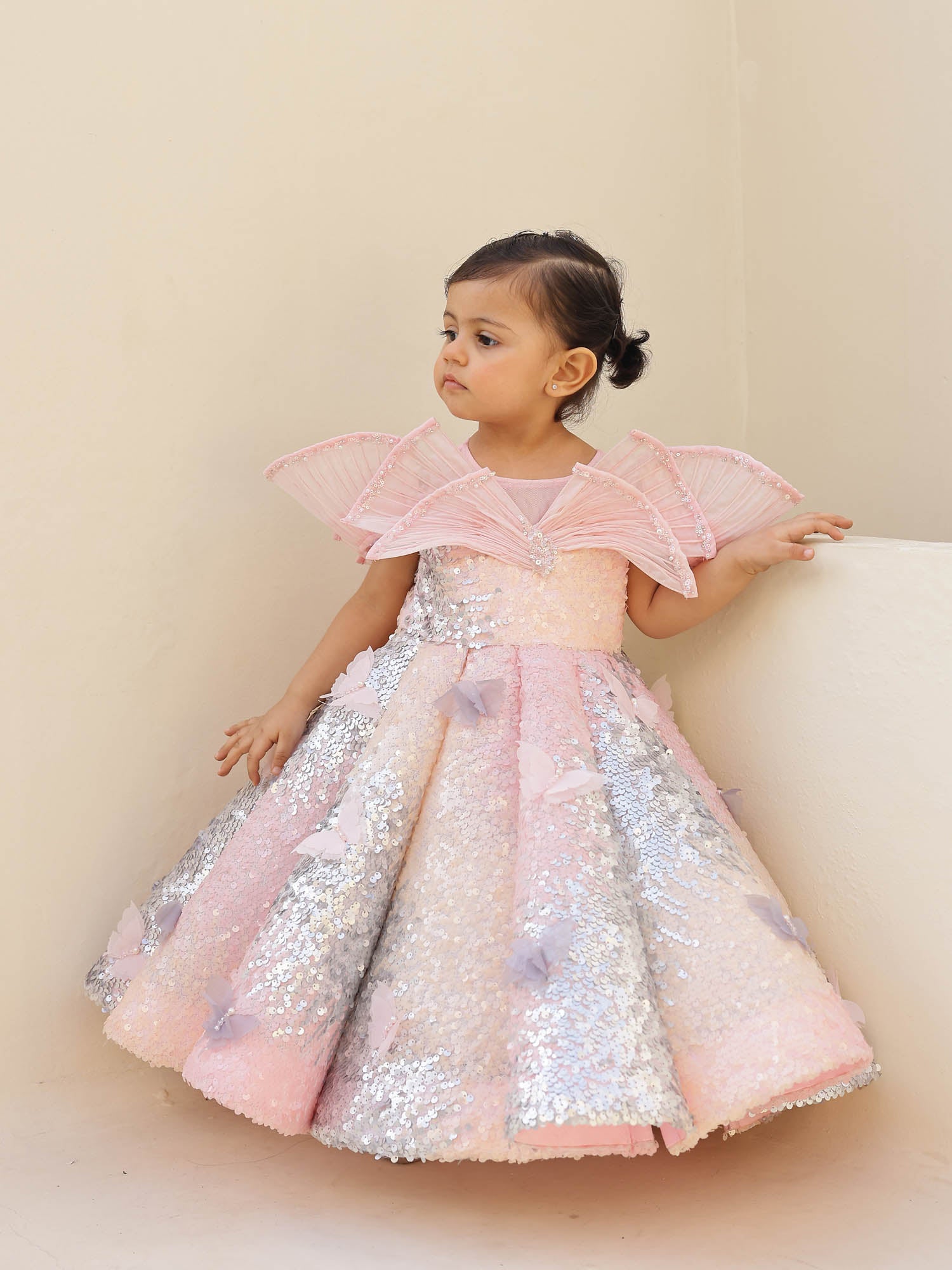 Luxury pink ombre sequin gown featuring a wired draped neckline, pearls, and butterflies—ideal for first birthdays and party occasions.