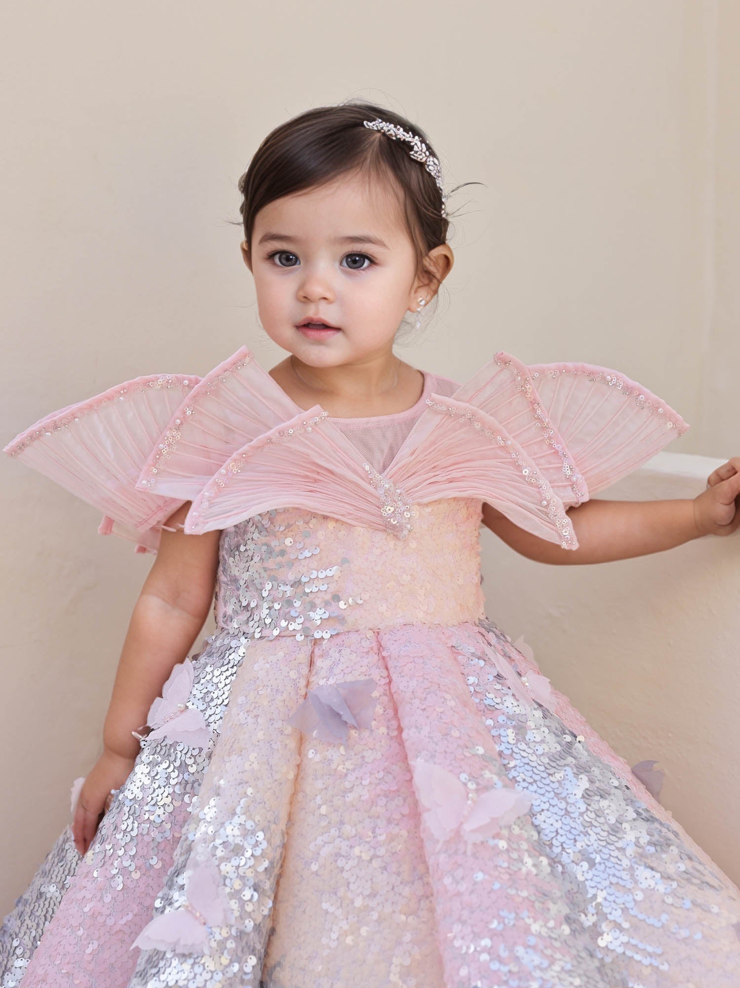 Sparkling pink shaded sequin gown with a wired neckline and butterfly detailing, perfect for birthday shoots and festive events.