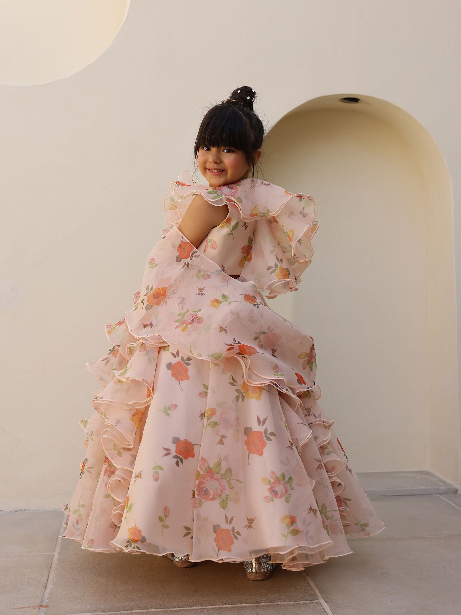 Kids festive wear peach floral lehenga crafted in organza with ruffled layers and delicate floral prints.